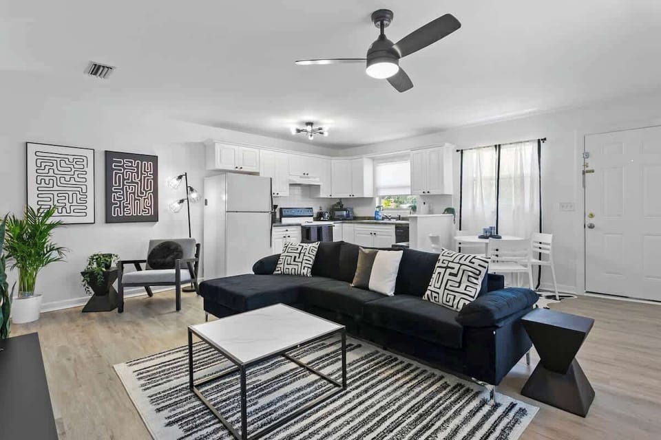 Kick back in style – our spacious black-and-white living room features a 65-inch smart TV for epic movie nights