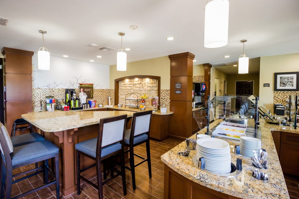 Dining area with seating and breakfast food display.