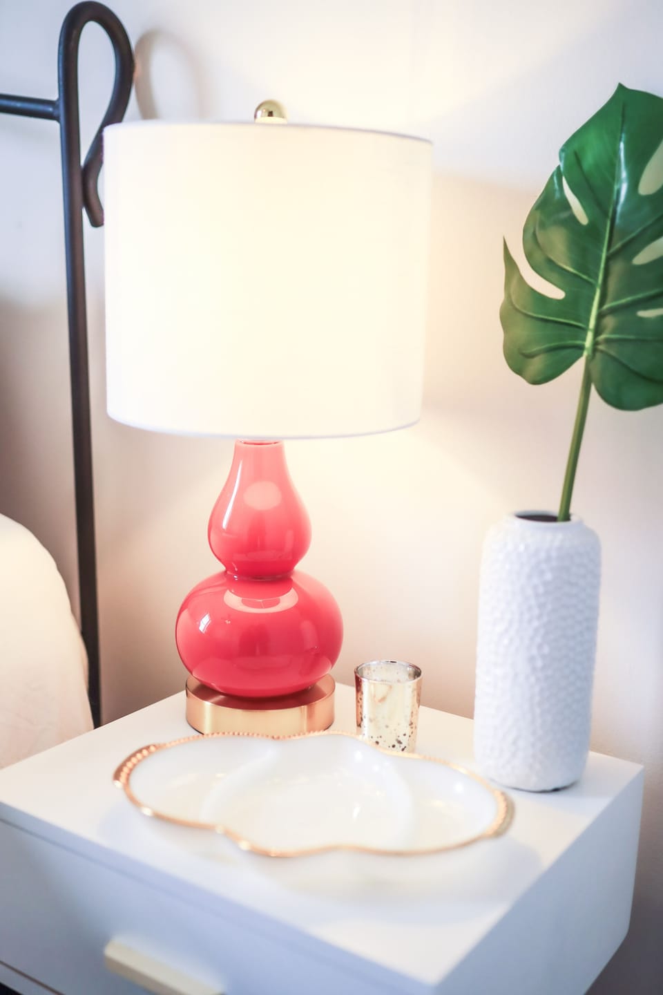 Stylish lamp and bedside table in bedroom with queen