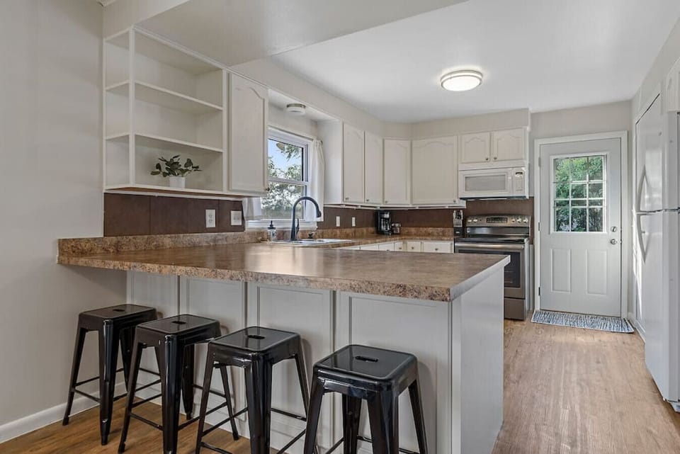 Modern kitchen area featuring a sleek countertop with four comfortable stools—perfect for casual meals, coffee, or socializing while you cook.