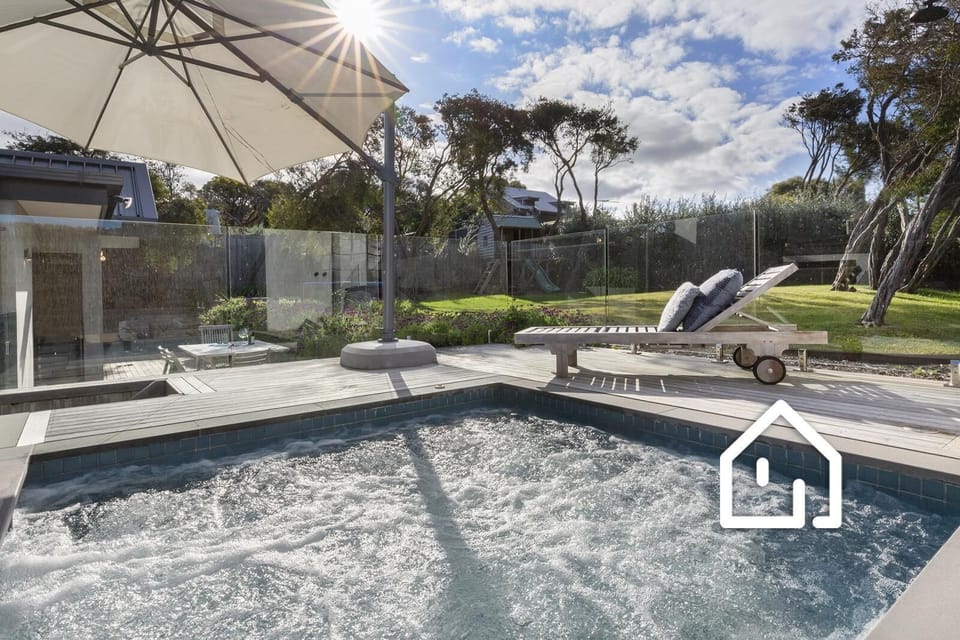 Spa looking out to the backyard gardens with cubby house, sandpit and trampoline