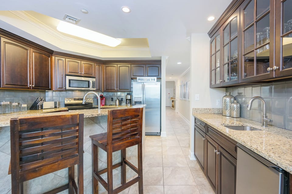 This kitchen features dark cabinetry, stainless appliances, breakfast bar, a Keurig and coffee maker for your favorite cup