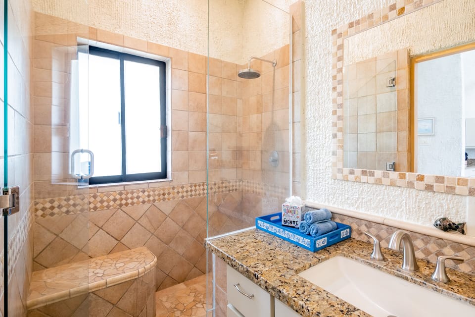 Relax in this large tiled shower with a rain showerhead...