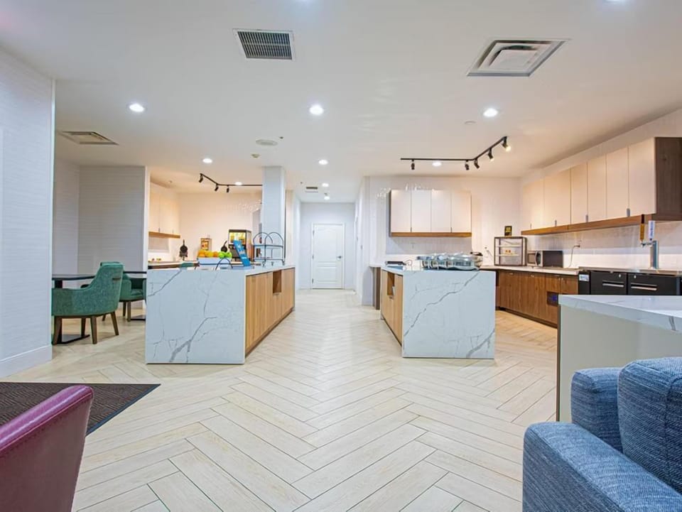 Modern shared kitchen with white cabinetry and appliances.