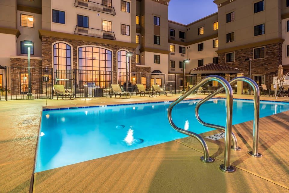 Outdoor pool area with lounge seating and evening lighting.
