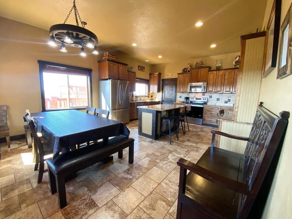 Alongside the kitchen island, this spacious dining area features a large table that comfortably seats eight with four chairs and a bench at each end.
