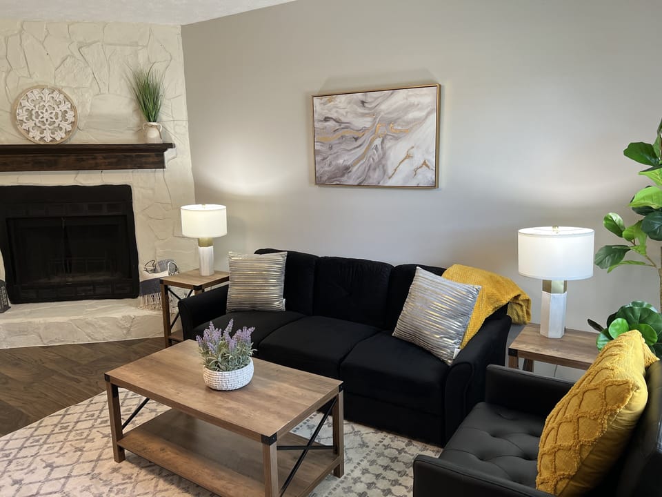 Comfy living room with a TV and wood burning fireplace.