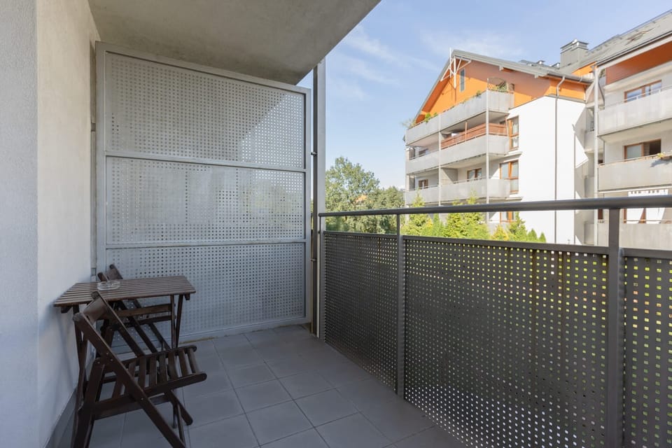 Spacious balcony with outdoor furniture. 