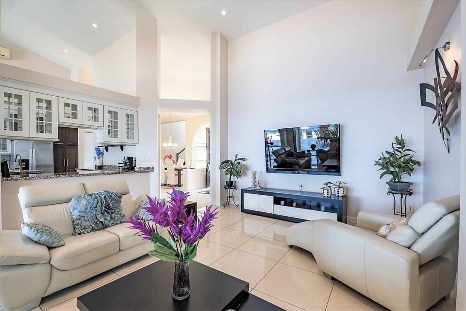 Livingroom with large 70" TV and sliding doors to the dining area on the porch