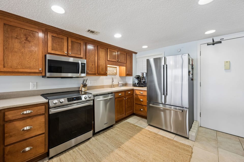 Your fully equipped kitchen features stainless steel appliances, warm wood cabinetry, and everything you need to prepare your favorite meals in comfort.