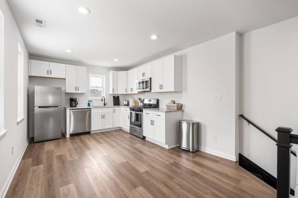 The kitchen is complete with plates, bowls, glasses, pots, pans, and cooking tools neatly tucked away in ample cabinet space, making meal preparation a breeze.
