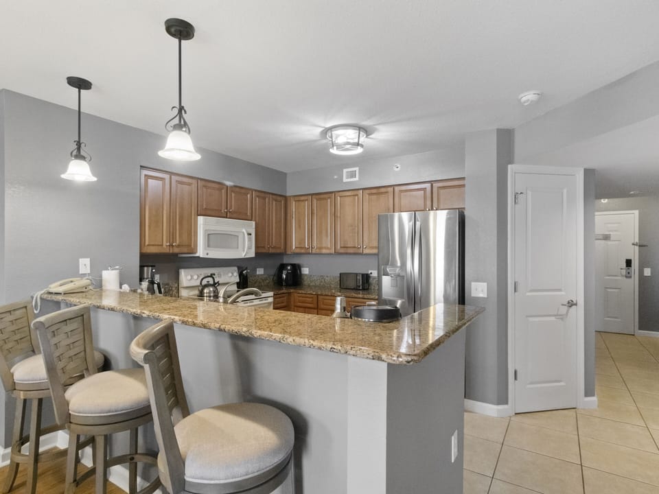 Your spacious kitchen invites culinary adventures with granite counters, modern appliances, and a breakfast bar perfect for morning coffee.