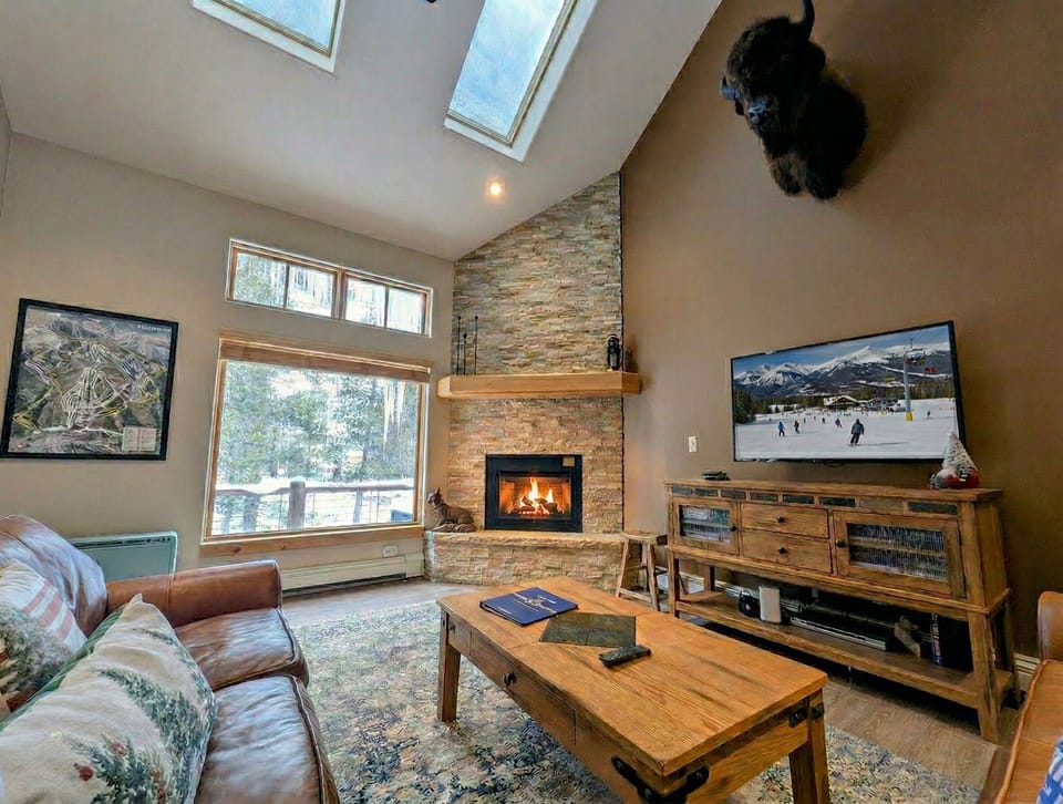Spacious Living Room with Large Picture Windows and Cozy Fireplace