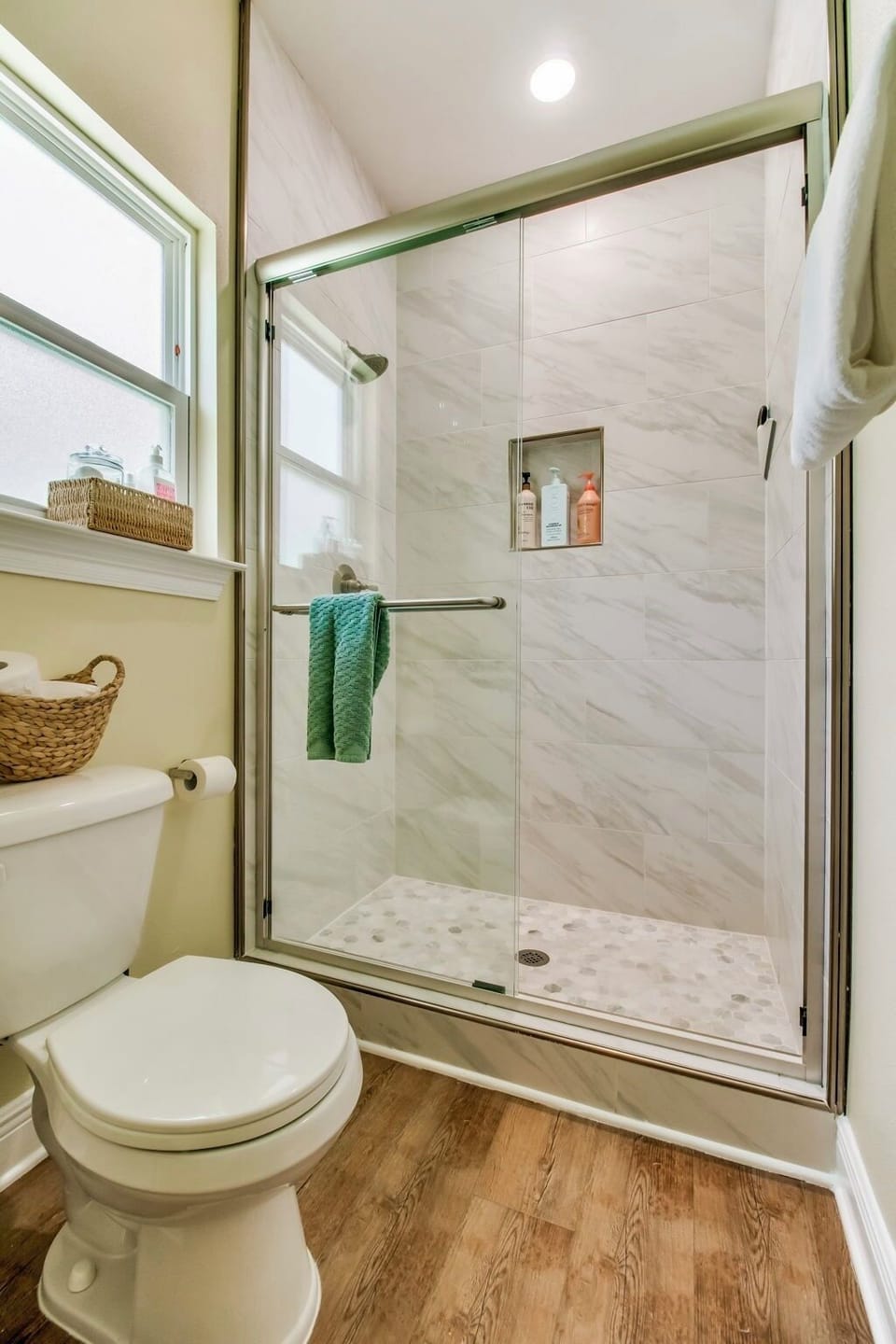 Bright modern bathroom with walk-in glass shower and stylish tile