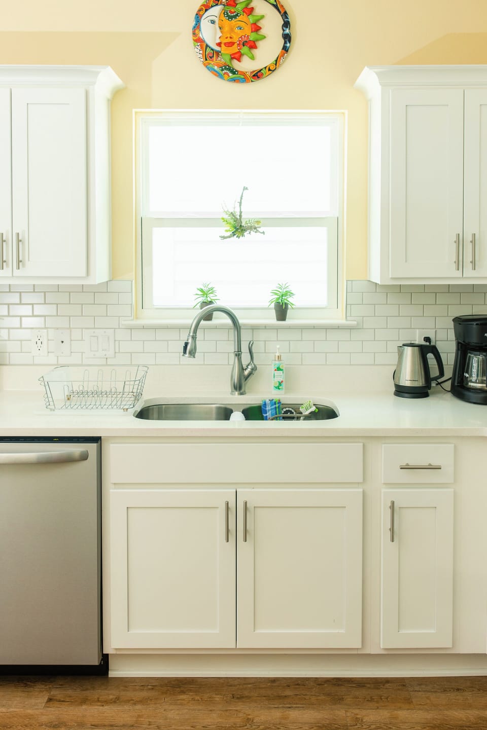 Bright white kitchen with sunny window, subway tile, and modern finishes