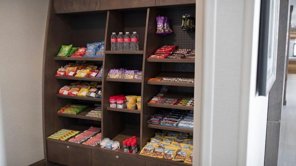 On-site pantry shelves stocked with snacks, candy, and bottled water
