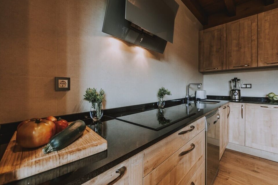 Modern kitchen with sleek black countertops and stainless steel appliances.