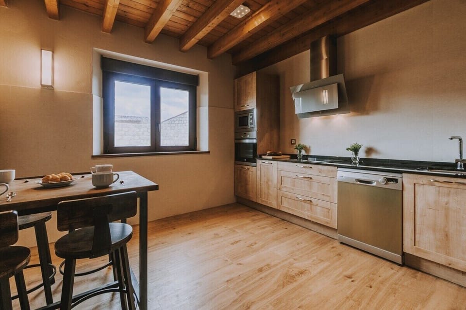 Rustic kitchen with modern appliances and charming wooden beams, perfect for cozy gatherings.