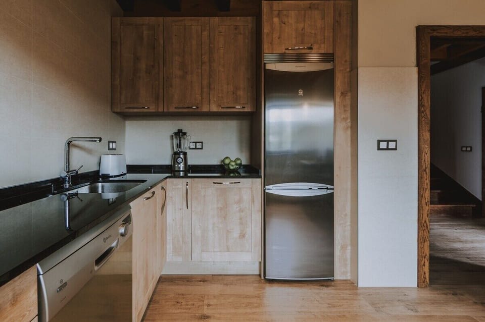 Modern kitchen with stainless steel appliances and sleek wooden cabinetry.