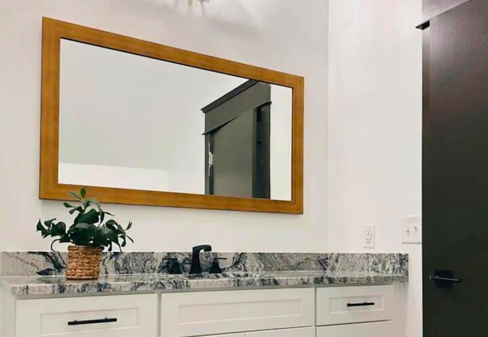 Freshen up in our modern bathroom, where the large mirror and ample lighting
