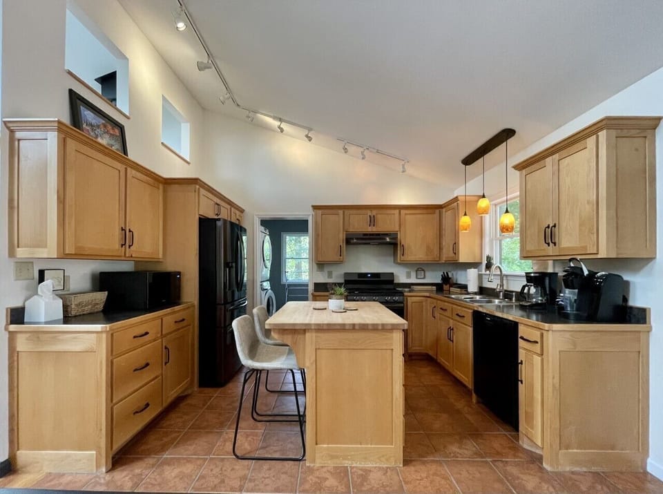 Fully stocked kitchen has new appliances,  door goes to the laundry, & back door