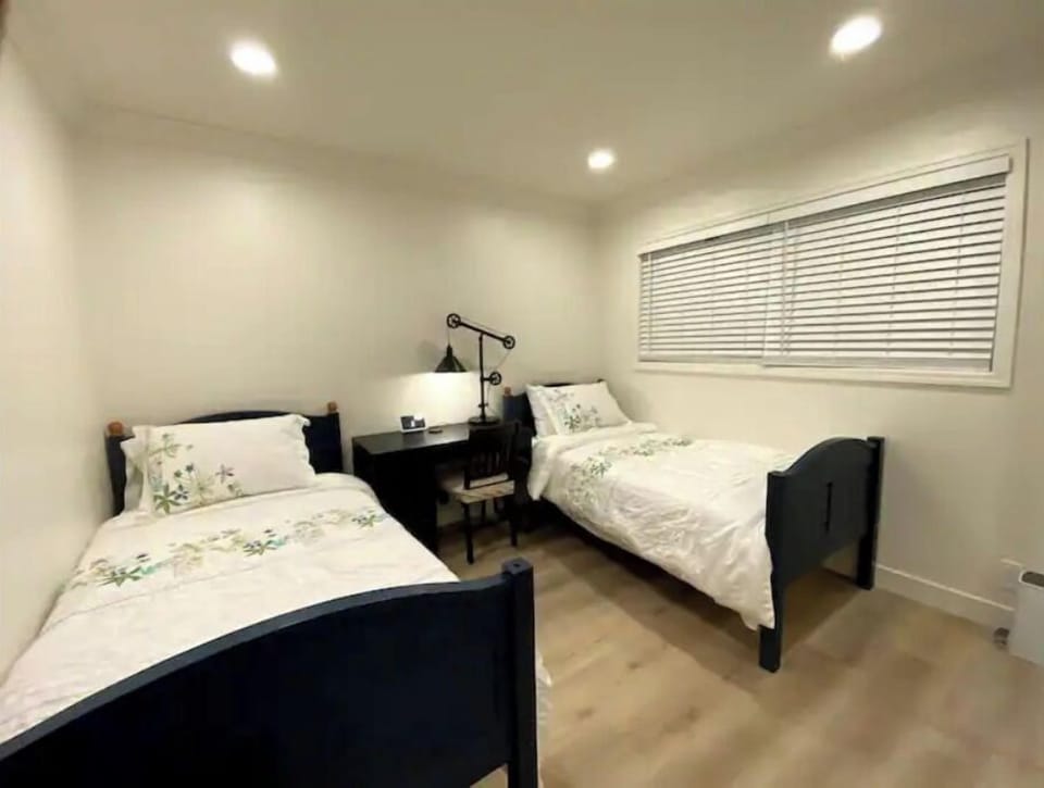 Two twin beds with a google home display and a desk