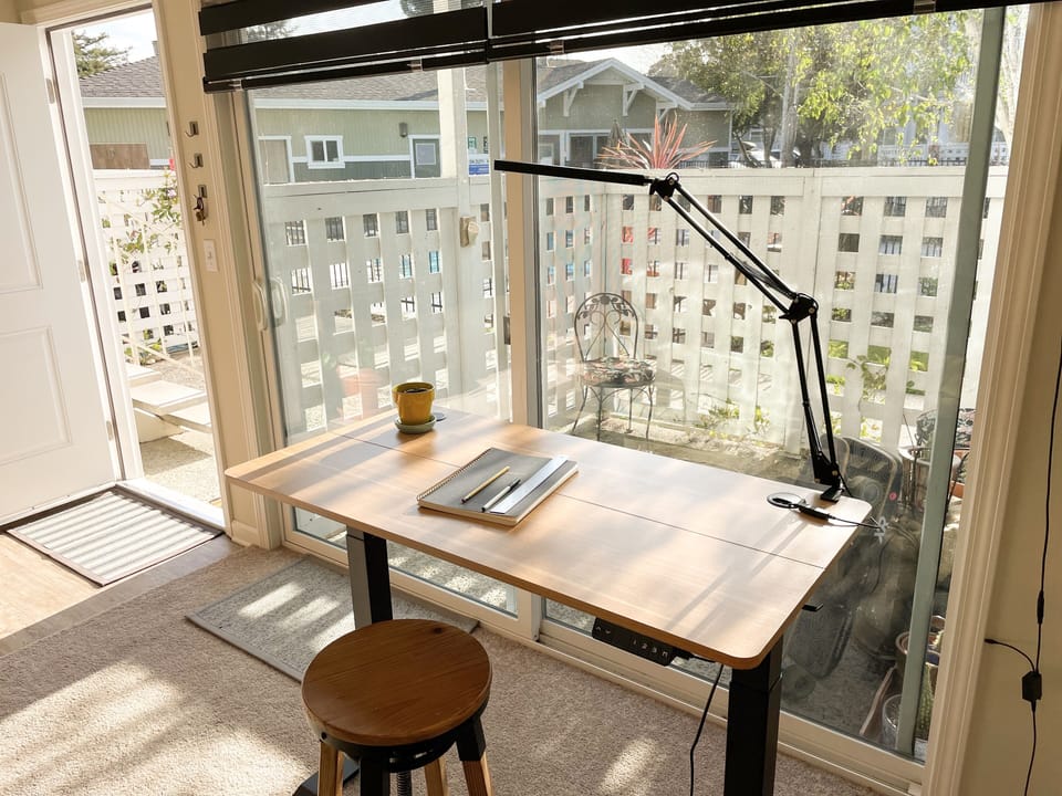 working area. Includes rising desk, lamp, notebook, and writing utensils.