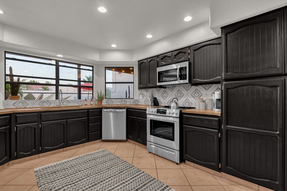 Stainless steel appliances include a dishwasher, electric oven and cooktop, microwave and refrigerator.
