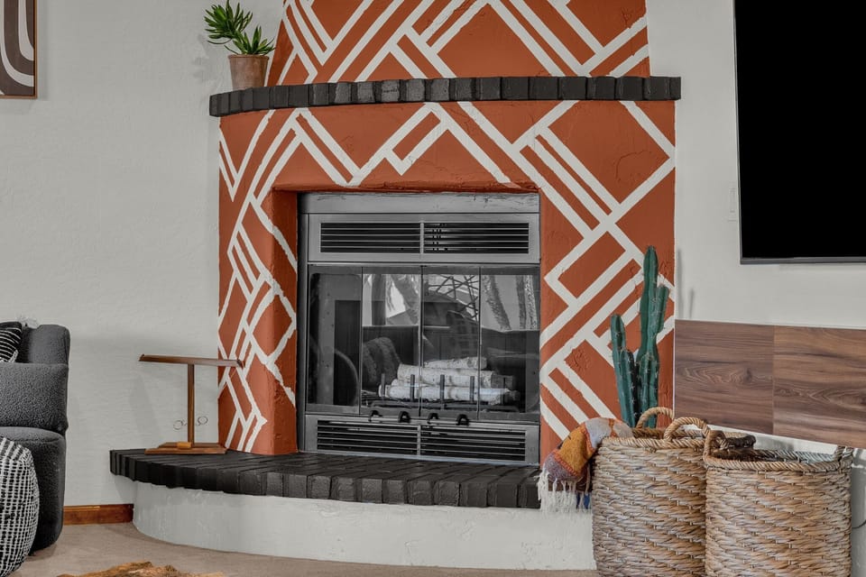 Non-operating fireplace is decorated with faux wood.