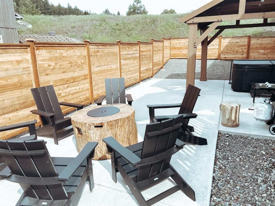 Outdoor, fully fenced patio is equipped with a brand new propane firepit, hot tub and BBQ!