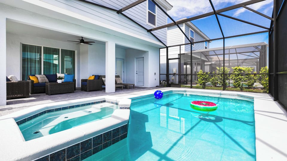 Dive into serenity with this sun-drenched private pool and spa oasis under the Florida sky.