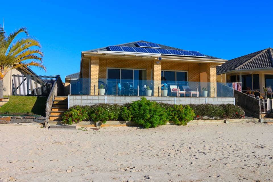 View of the rear patio from the private beach. 