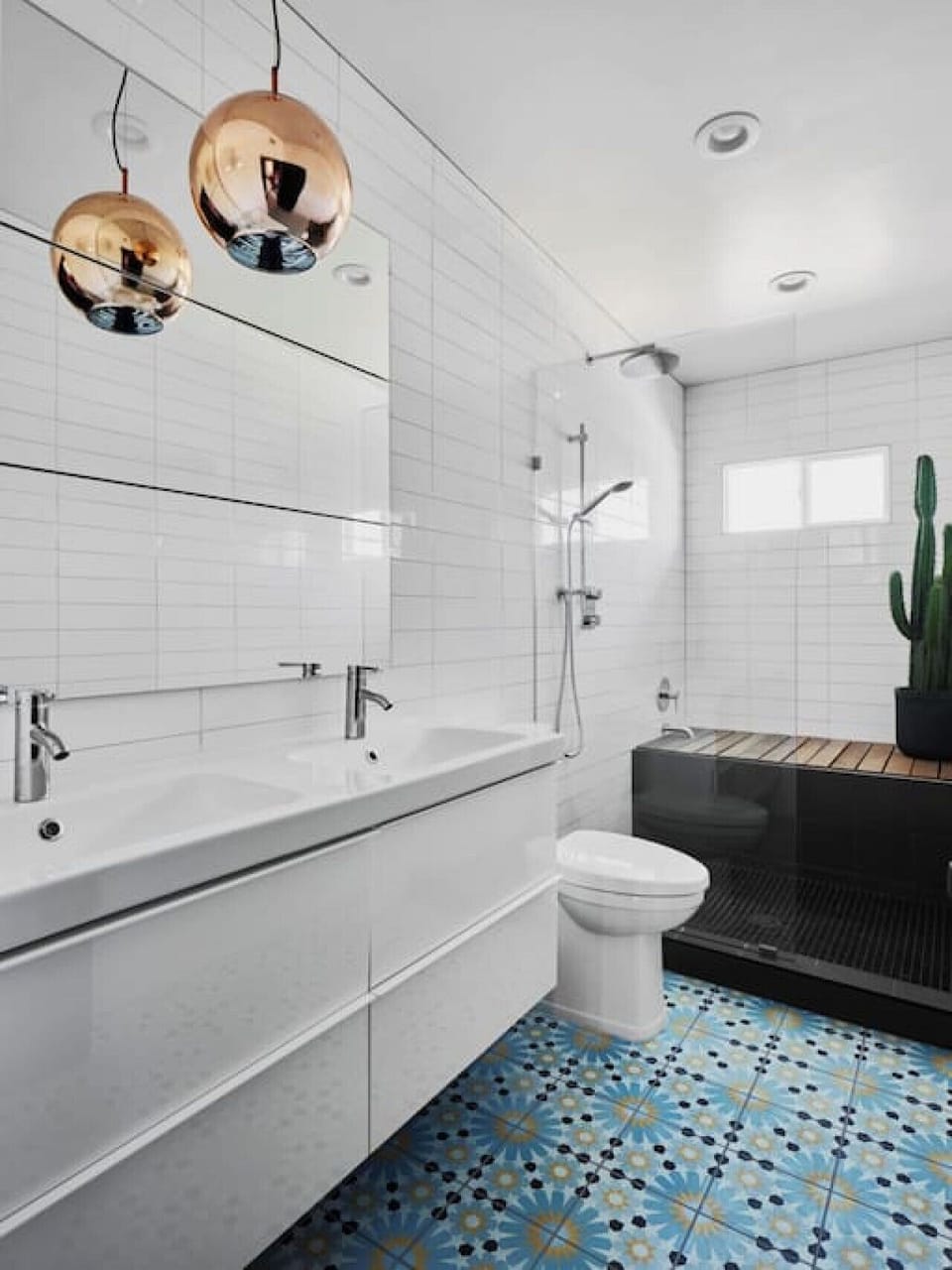 Shared bathroom with a double vanity sink, toilet, walk-in shower, and a tub bench
