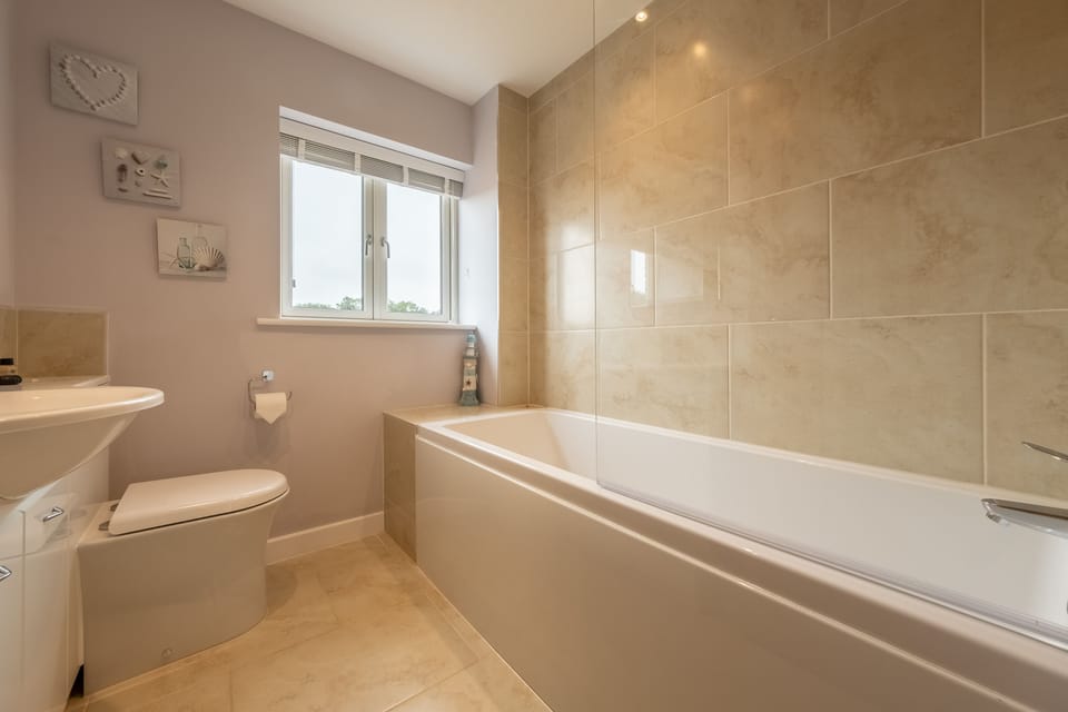 First floor: Family bathroom with bath and shower over