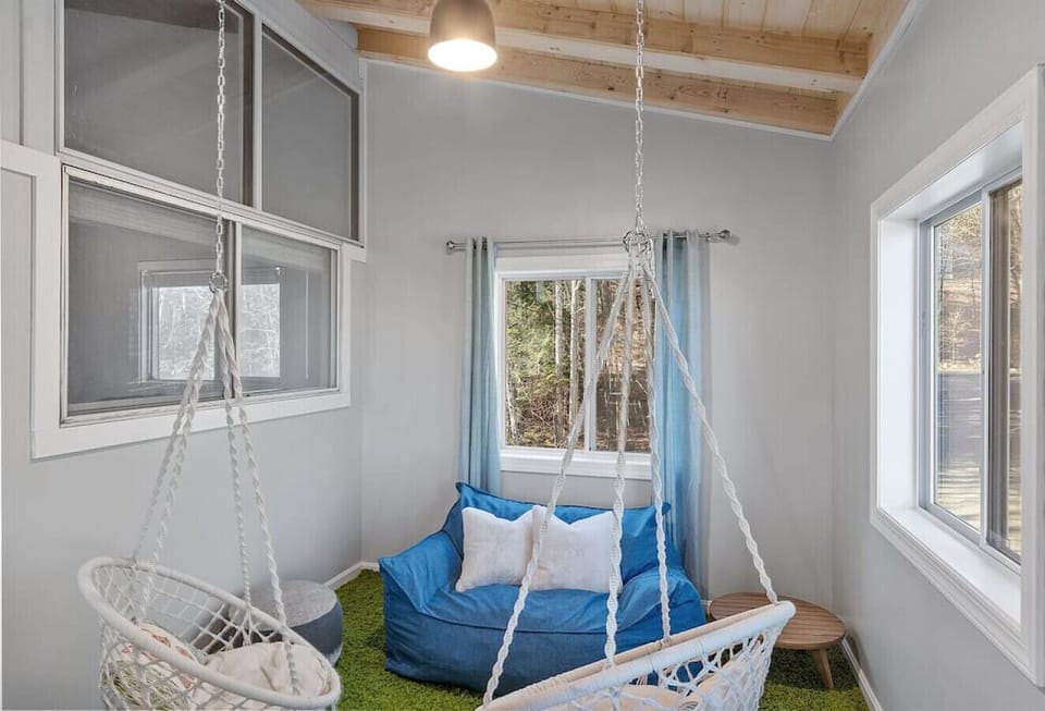 Loft area on second floor with two kids swing chairs and a small seating.