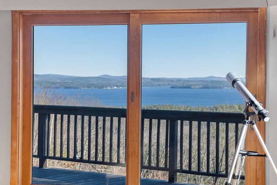 Second Floor living room with Lake and mountain views, 15 feet ceiling, plenty of natural light, and a big deck.