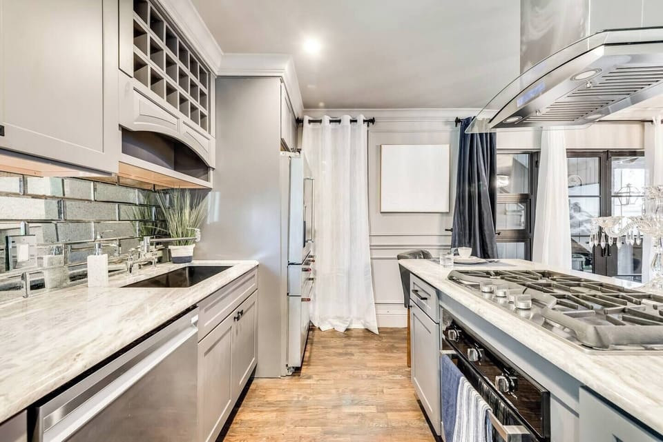 A fully equipped kitchen with a high-end gas cooktop, stove, French door refrigerator, and ample counter space—perfect for preparing gourmet meals for yourself or guests.