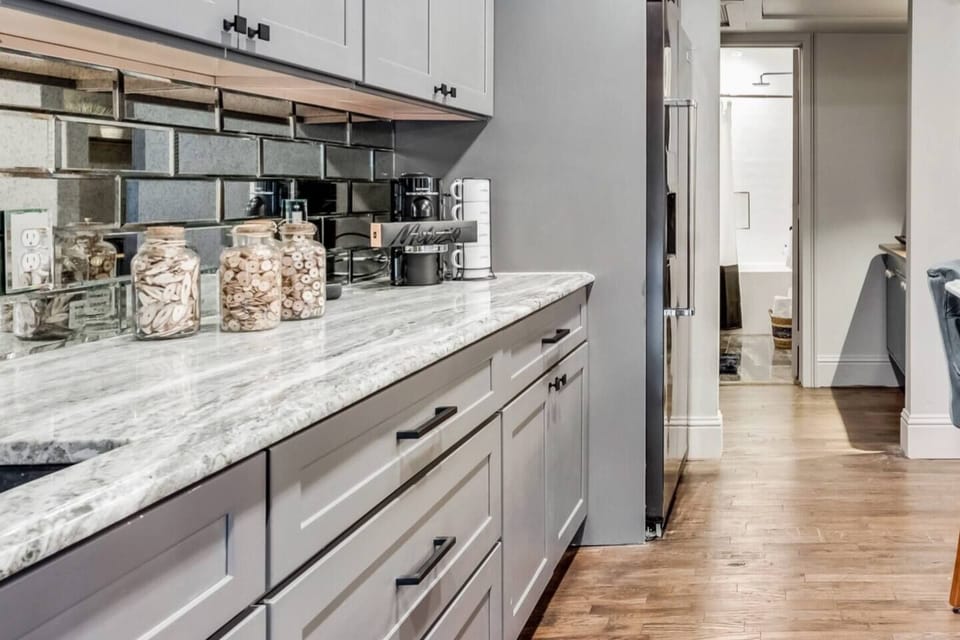 A brand new kitchen featuring ample storage, a Nespresso machine, and elegant marble countertops.

The open concept is great for having cooking and conversation.