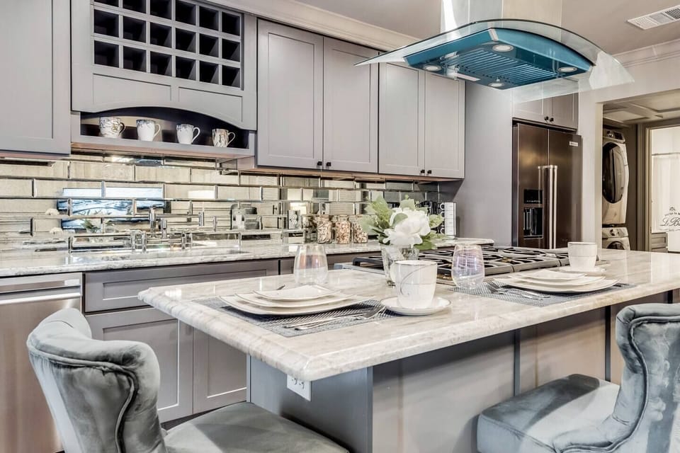 A fully equipped gourmet kitchen with a gas range, stainless steel vent hood, and all the essentials, perfect for entertaining.