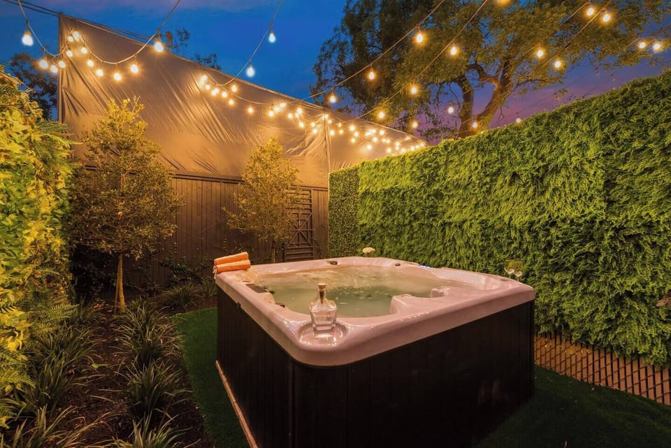Relax in the private courtyard hot tub, surrounded by upgraded privacy fences for a tranquil and intimate experience.