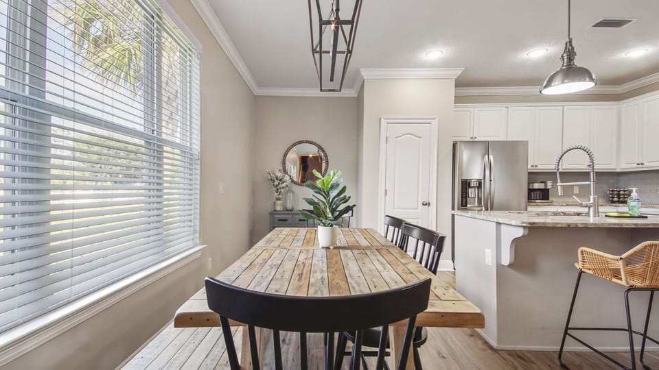 Kitchen table with 4 chairs and a bench.  There are 2 more chairs at the island