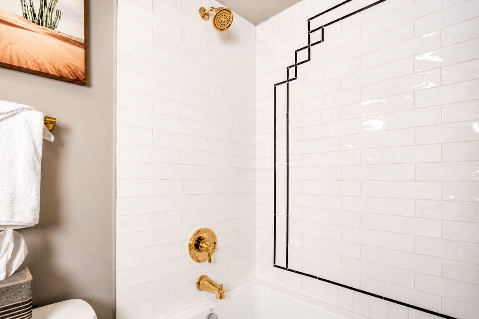 This luxurious bathroom features a soaking tub with a shower, complemented by plush towels for a spa-like experience.