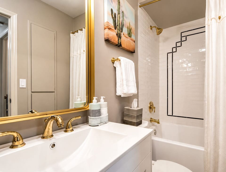 This luxurious bathroom features a soaking tub with a shower, complemented by plush towels for a spa-like experience.