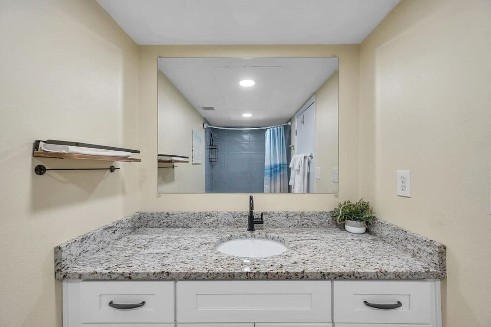 Spacious bathroom w/ wide vanity, mirror, & a fresh, modern feel.