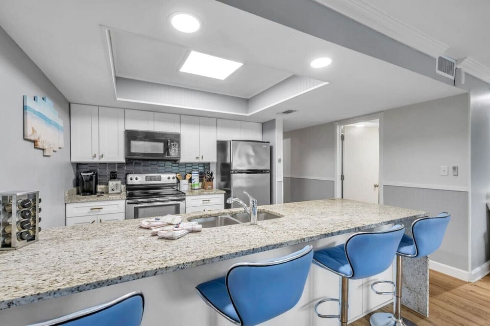 Spacious kitchen w/ bar seating, perfect for casual meals & conversation.