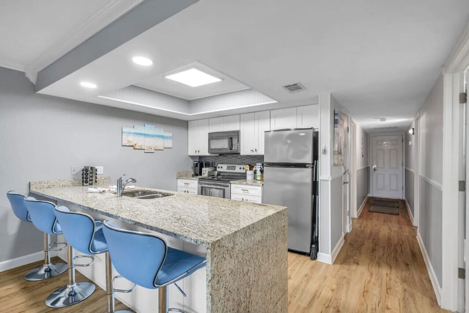 Fully equipped kitchen w/ granite counters, bar seating, & plenty of prep space.