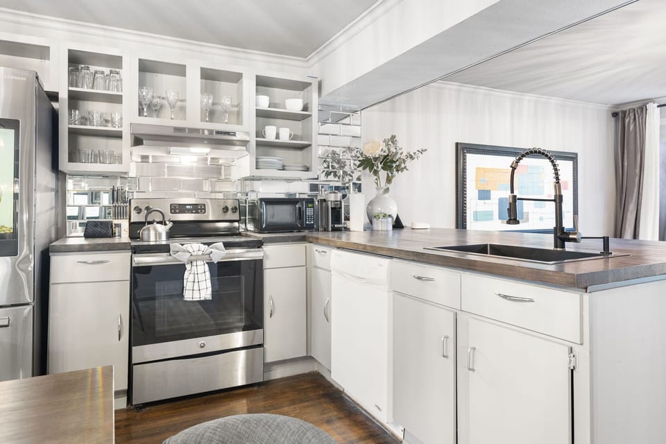 Bright, fully equipped kitchen with open shelving and prep space