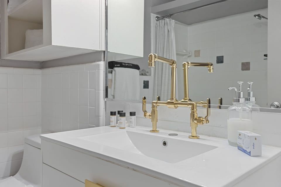 Elegant double vanity with gold accents and backlit mirrors

