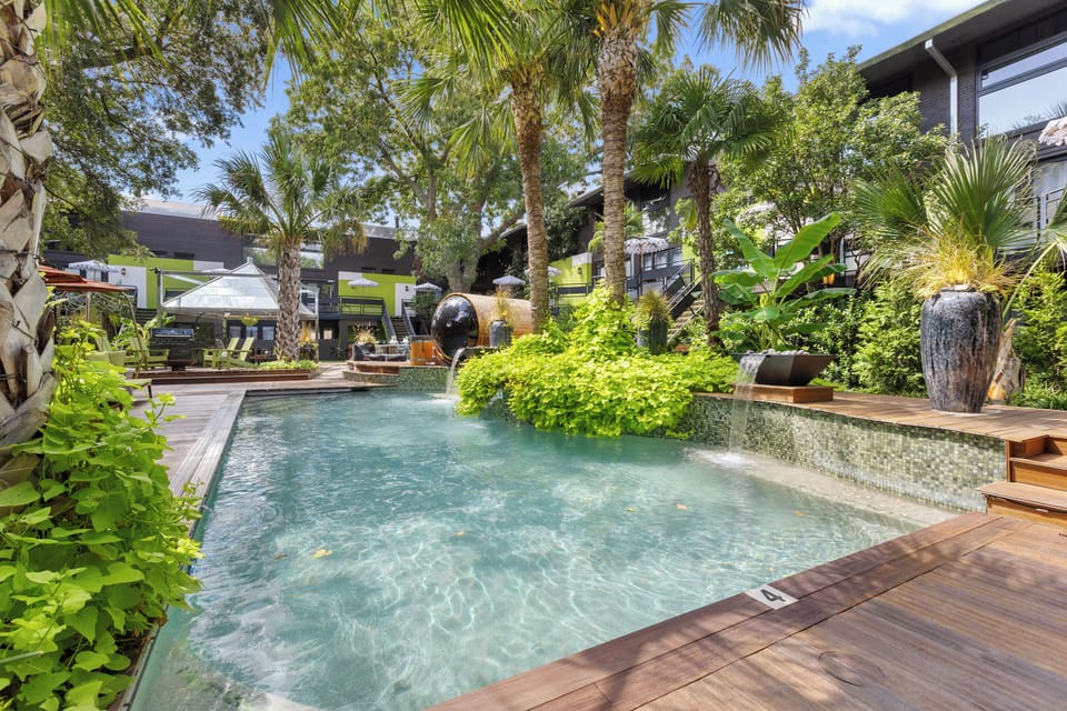 Peaceful resort-style pool surrounded by palm trees and greenery