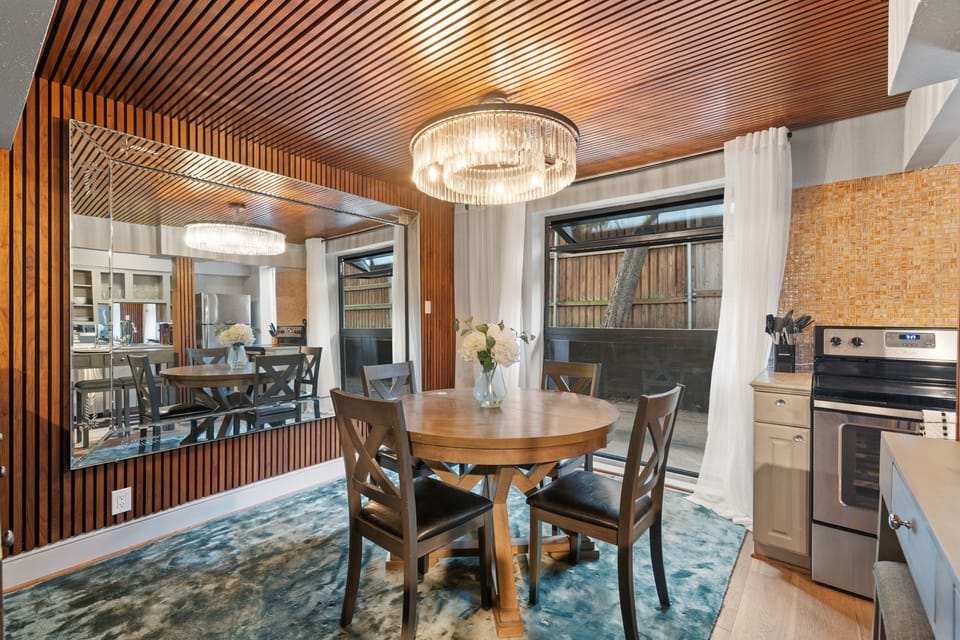 Dining Room with Views – Stylish dining area framed by large windows and a statement chandelier.